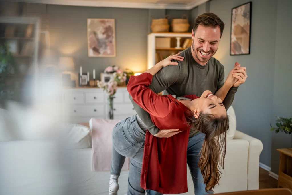 Couple dancing in living room celebrating meaningful Valentine’s Day at home