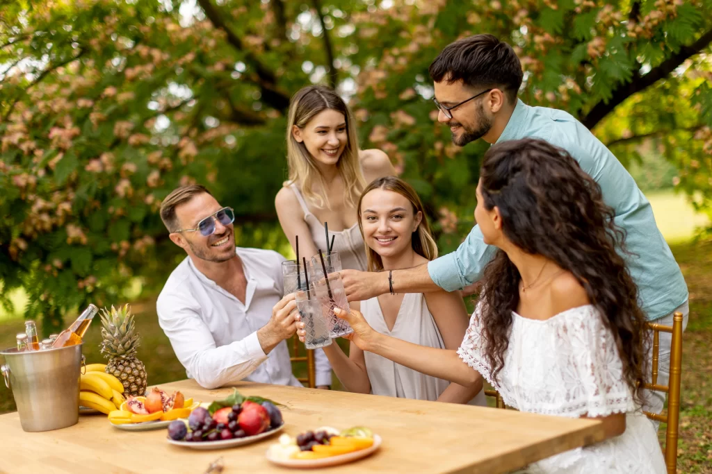 Summer Hydration Starts with Better Water: Why Water Quality Matters as Much as How Much You Drink 2 Group of friends toasting glasses of water outdoors at a summer gathering with fresh fruit and drinks on the table